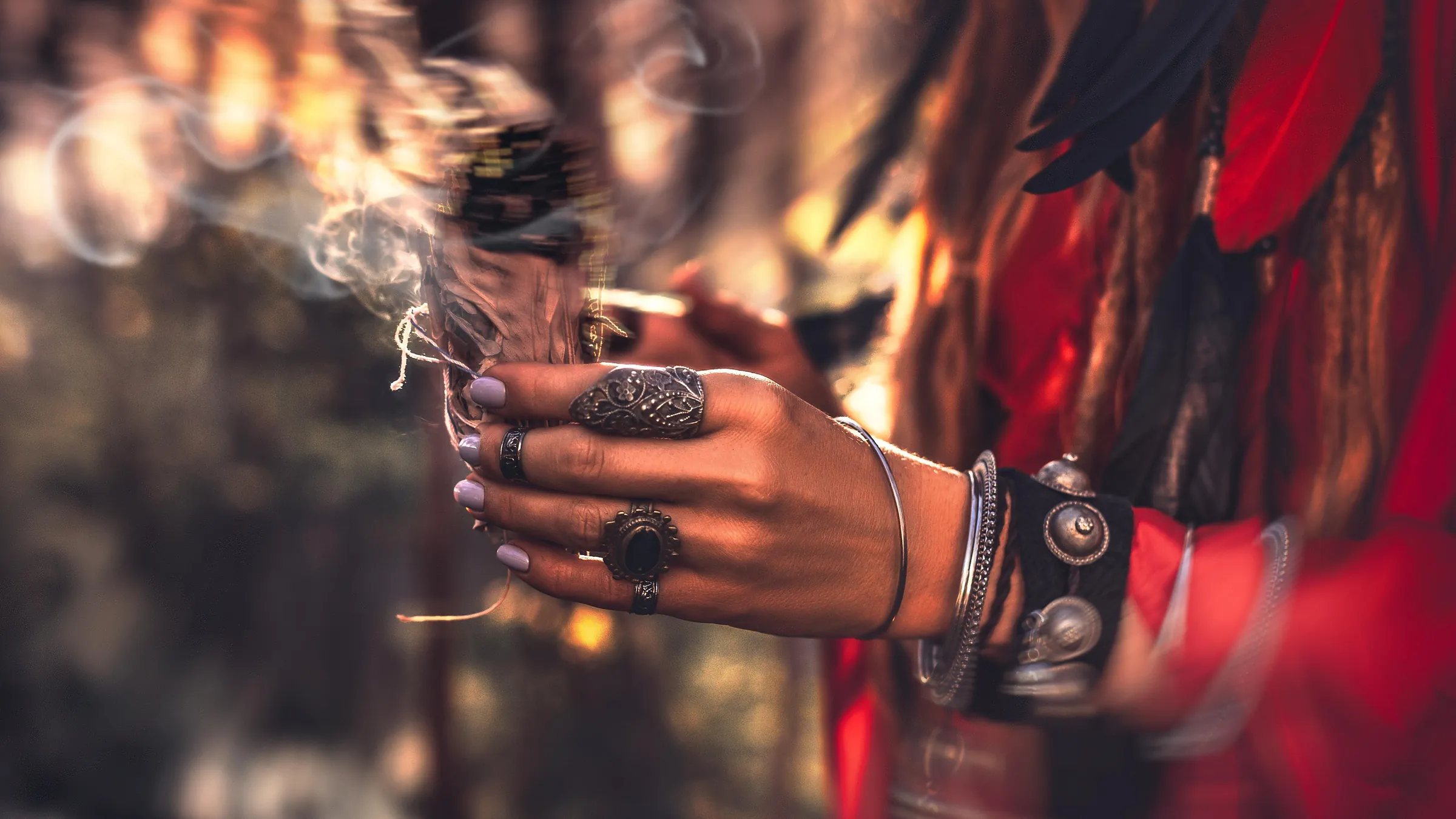 A hand holding smouldering sacred tobacco during ceremony